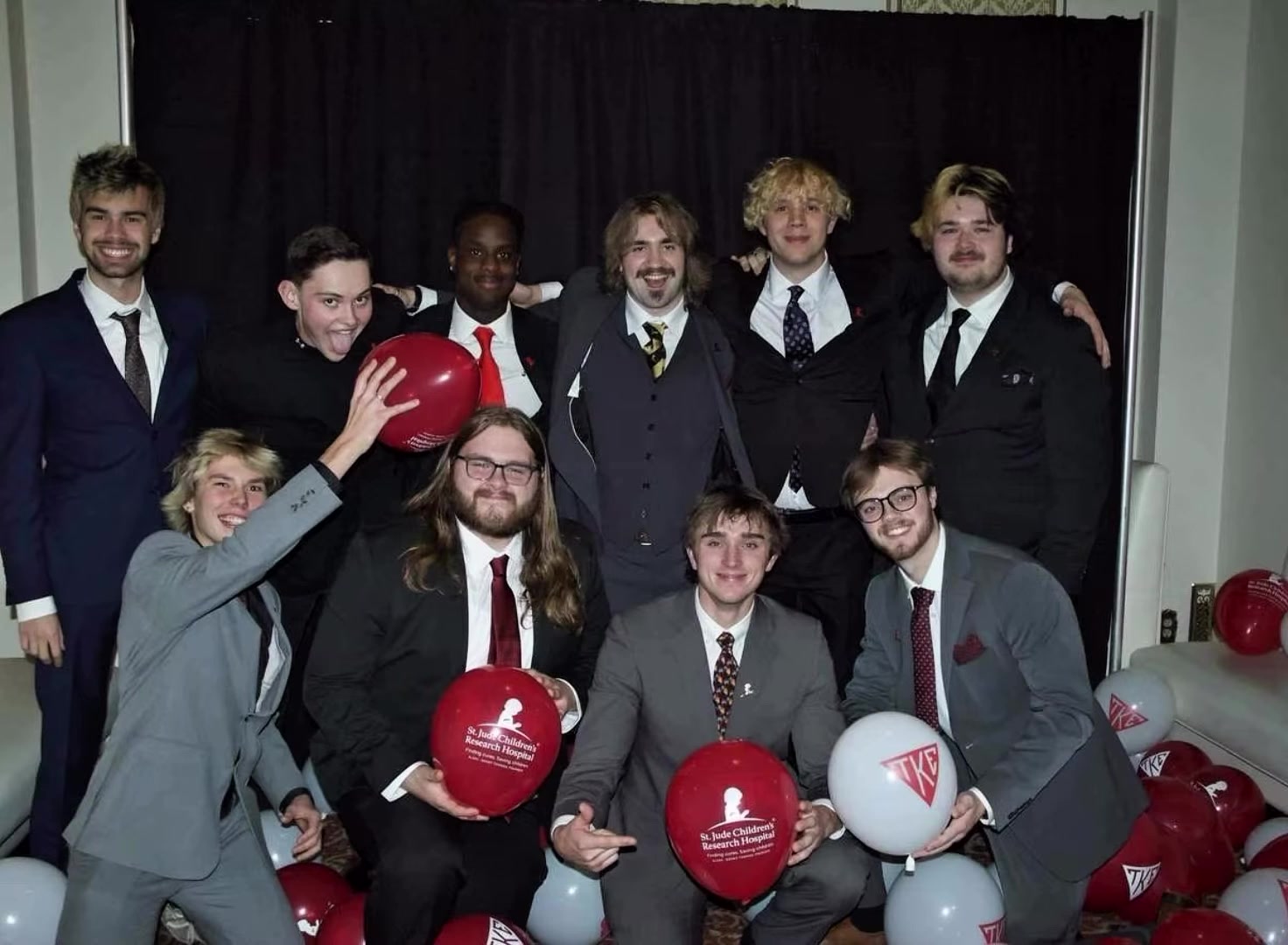 Brothers celebrating with St. Jude and TKE balloons