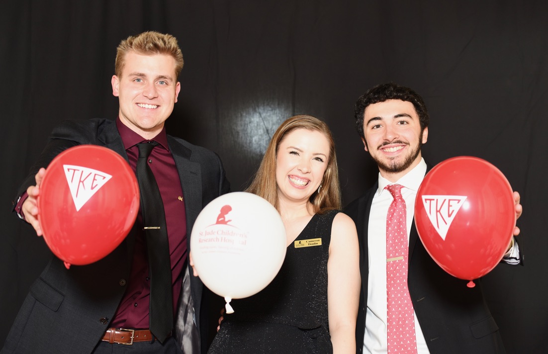Brothers with St. Jude representative holding TKE and St. Jude balloons