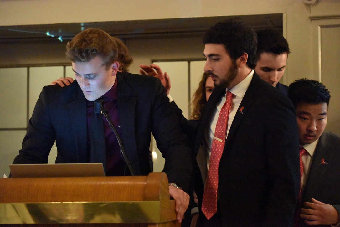 Brothers supporting a speaker at the podium