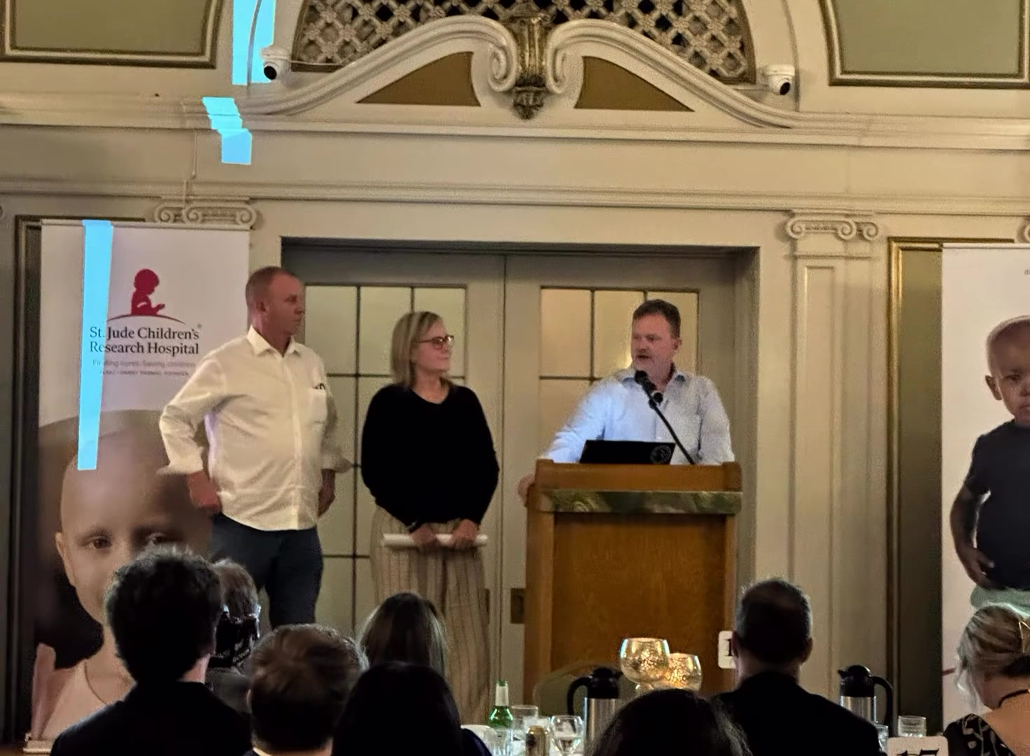 Chapter leaders speaking beside the St. Jude Children's Research Hospital banner